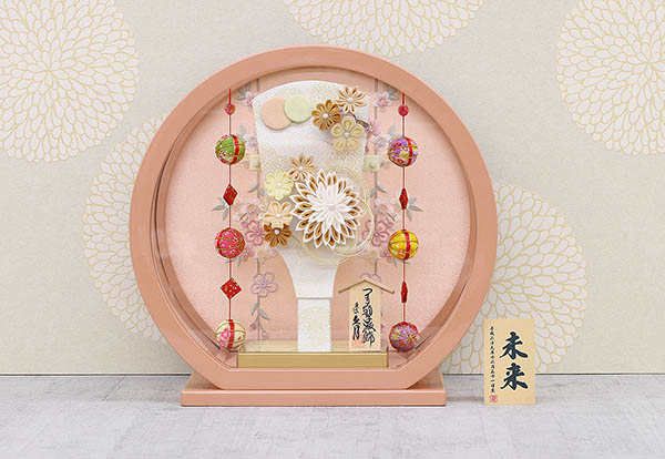 久月　 羽子板　つまみ細工 髪飾り付き 羽子板 茶 パールピンク塗り 鞠三連つるし付き 円形 丸型アクリルケース　詳細画像