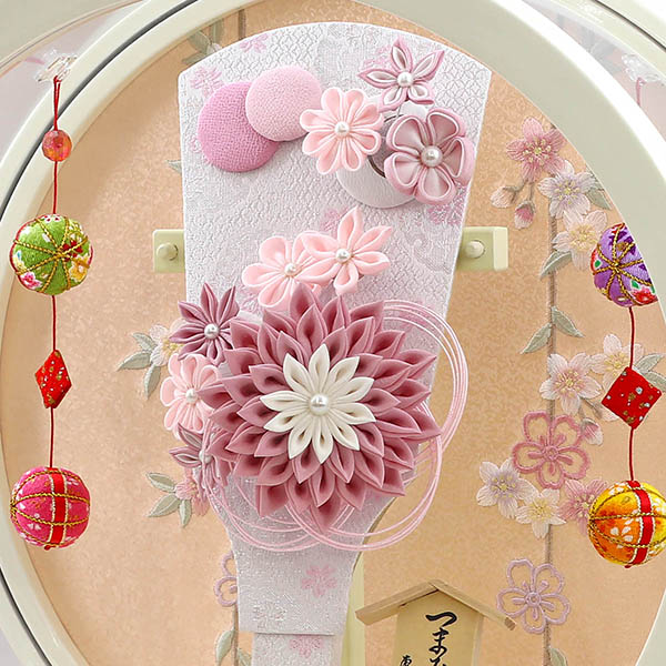 久月　 羽子板　つまみ細工 髪飾り付き 羽子板 桃 白塗り 鞠二連つるし付き 円形 丸型アクリルケース　詳細画像